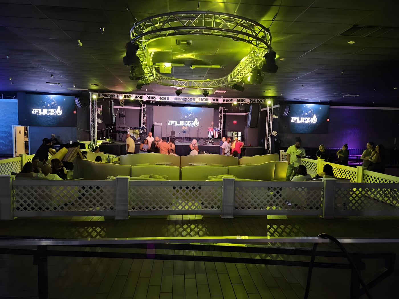 Plush VIP couches at the stage rail with the full room lit
